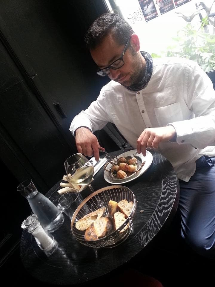 Serhan at the table — snails, bread, and wine